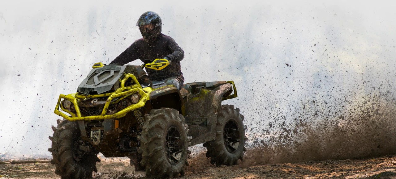 Rider On A Can-Am® Outlander™ ATV Kicking Up Mud