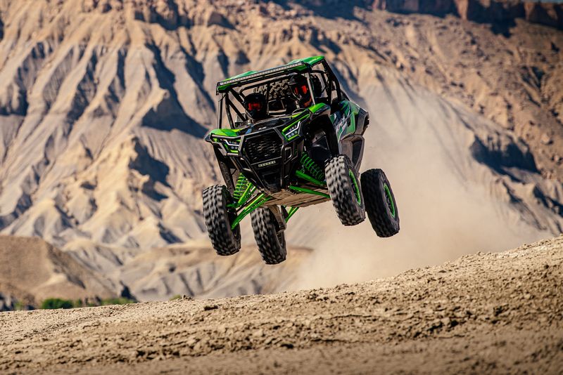 A side x side gets some huge air with all four wheels off the ground out on the dusty trails.