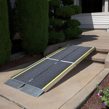  a mobility ramp placed outside of a home so that a wheelchair can get up the stairs
