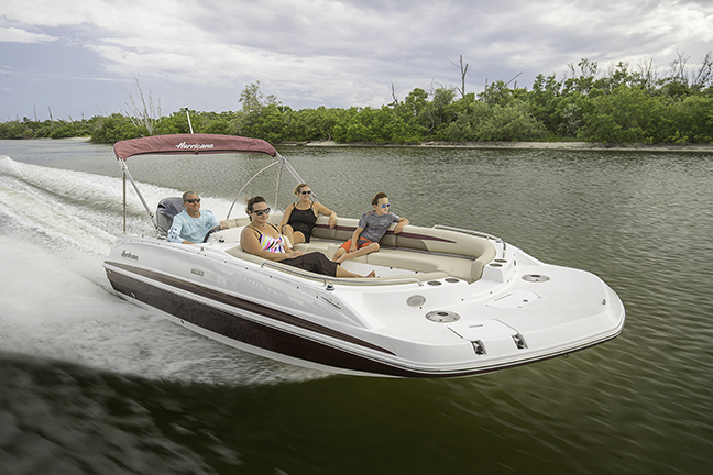 Family of four relaxing on a speeding Hurricane deck boat.